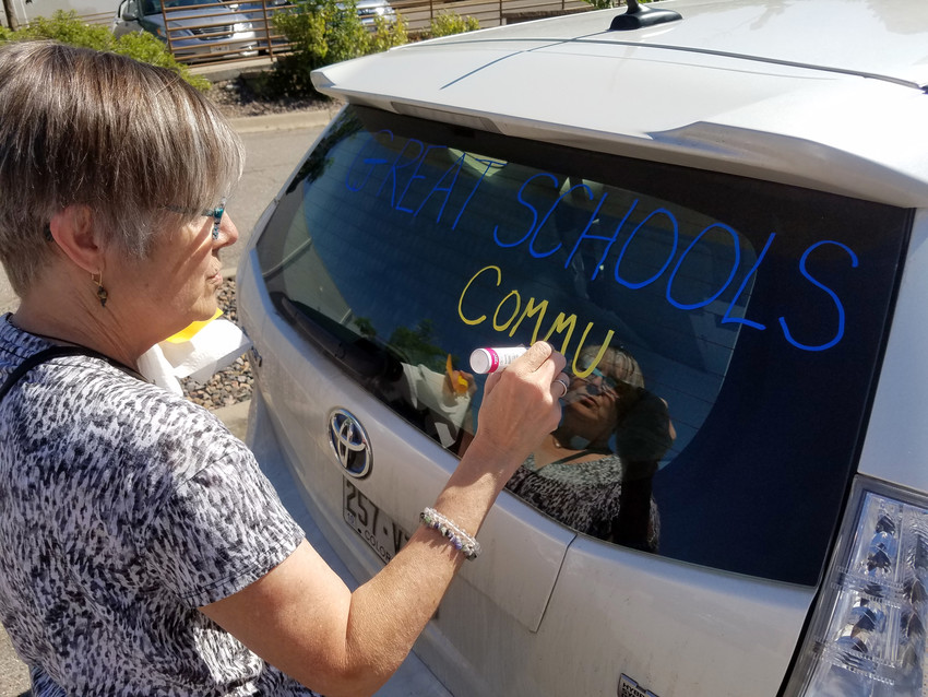 Volunteer Renee Howell paints a car that would later transport boxes of Initiative 93 signatures June 11 to the Secretary of State's office.